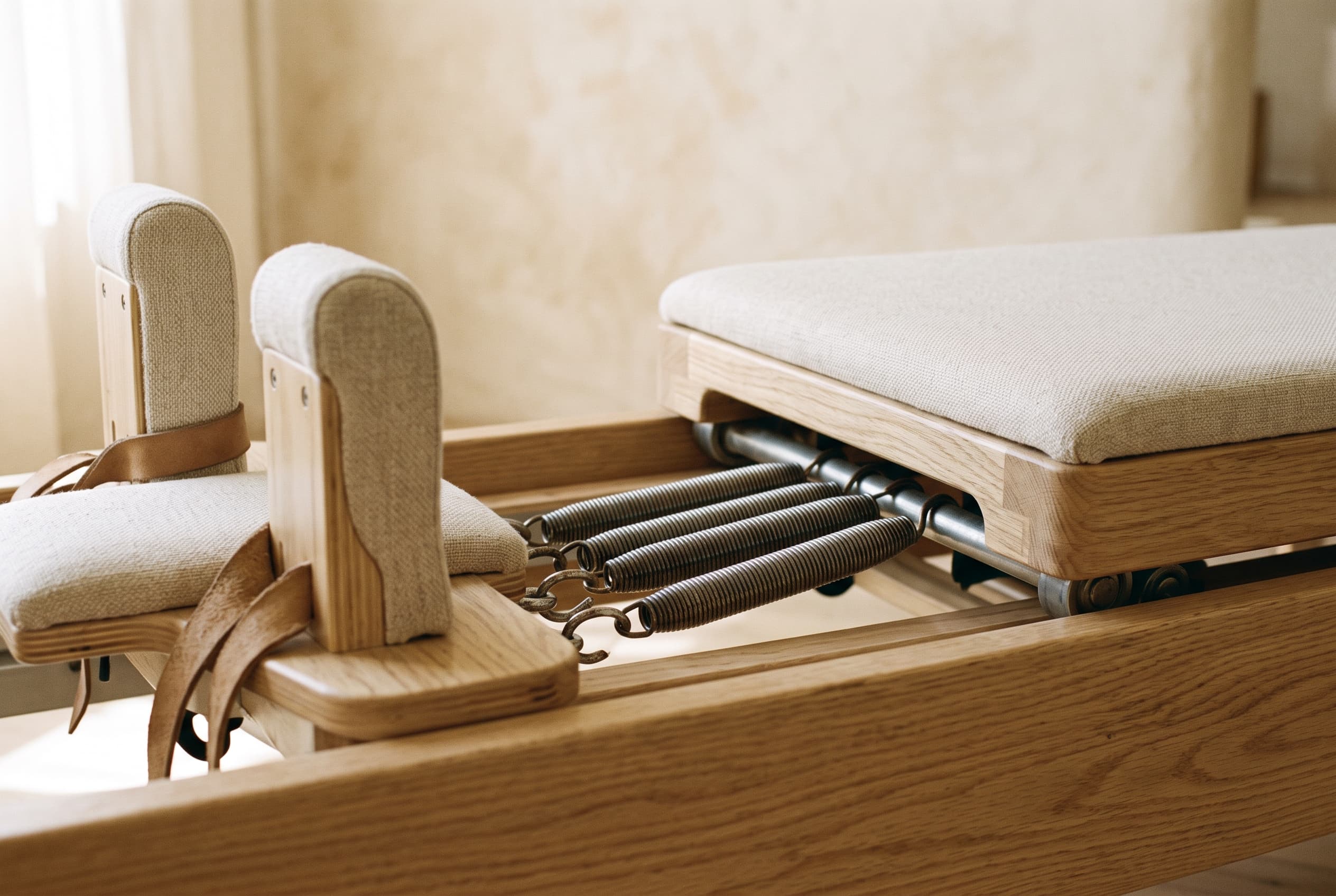 Detalj drvenog pilates reformera sa oprugama